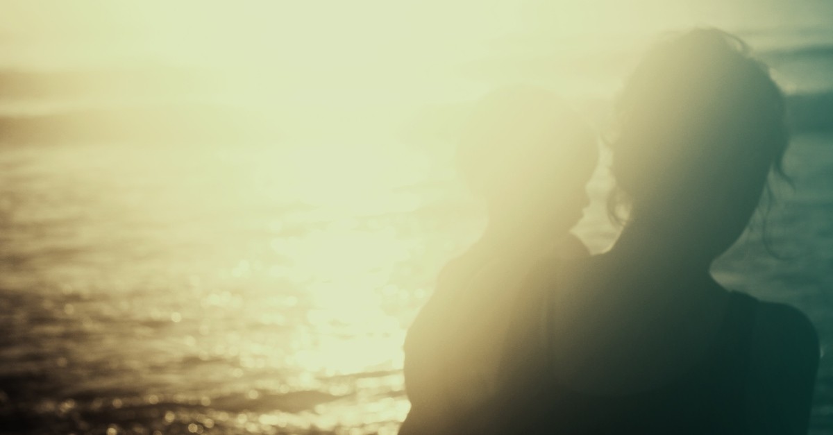 mother and chid silhouette by the water